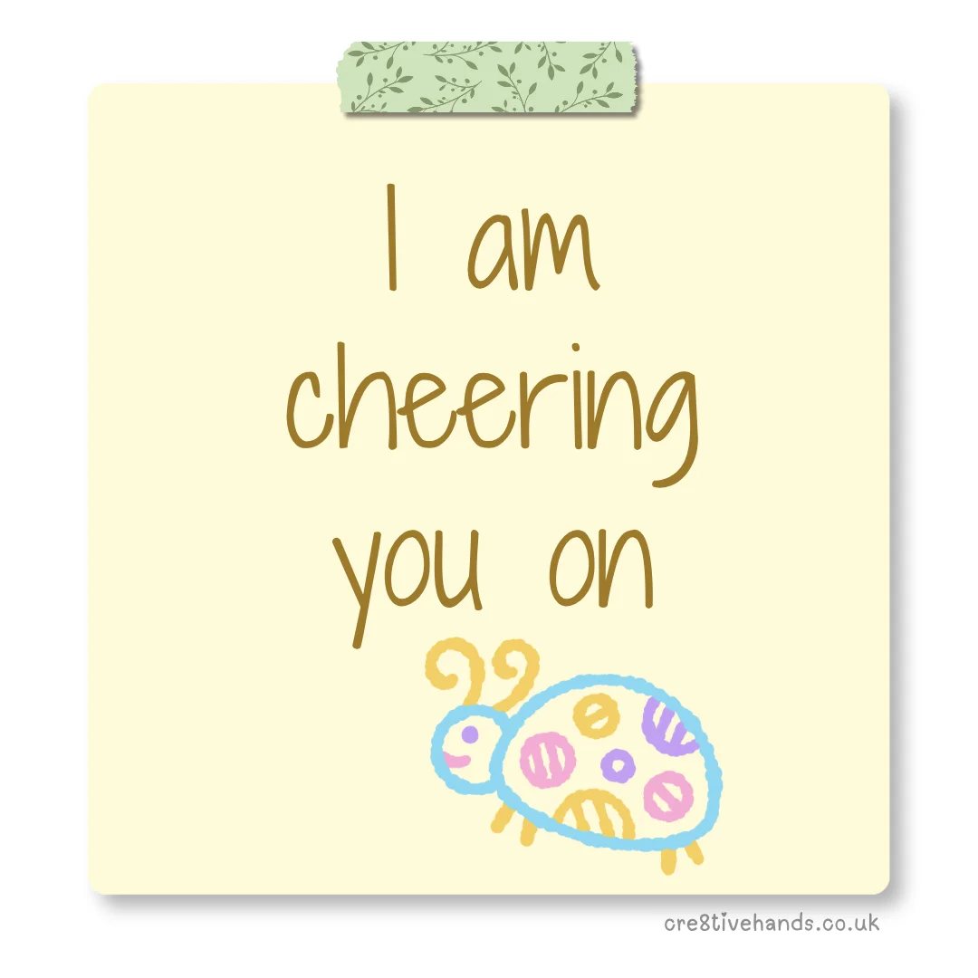 Pastel yellow sticky note with the message “I am cheering you on” with green floral tape and a colourful bug doodle.