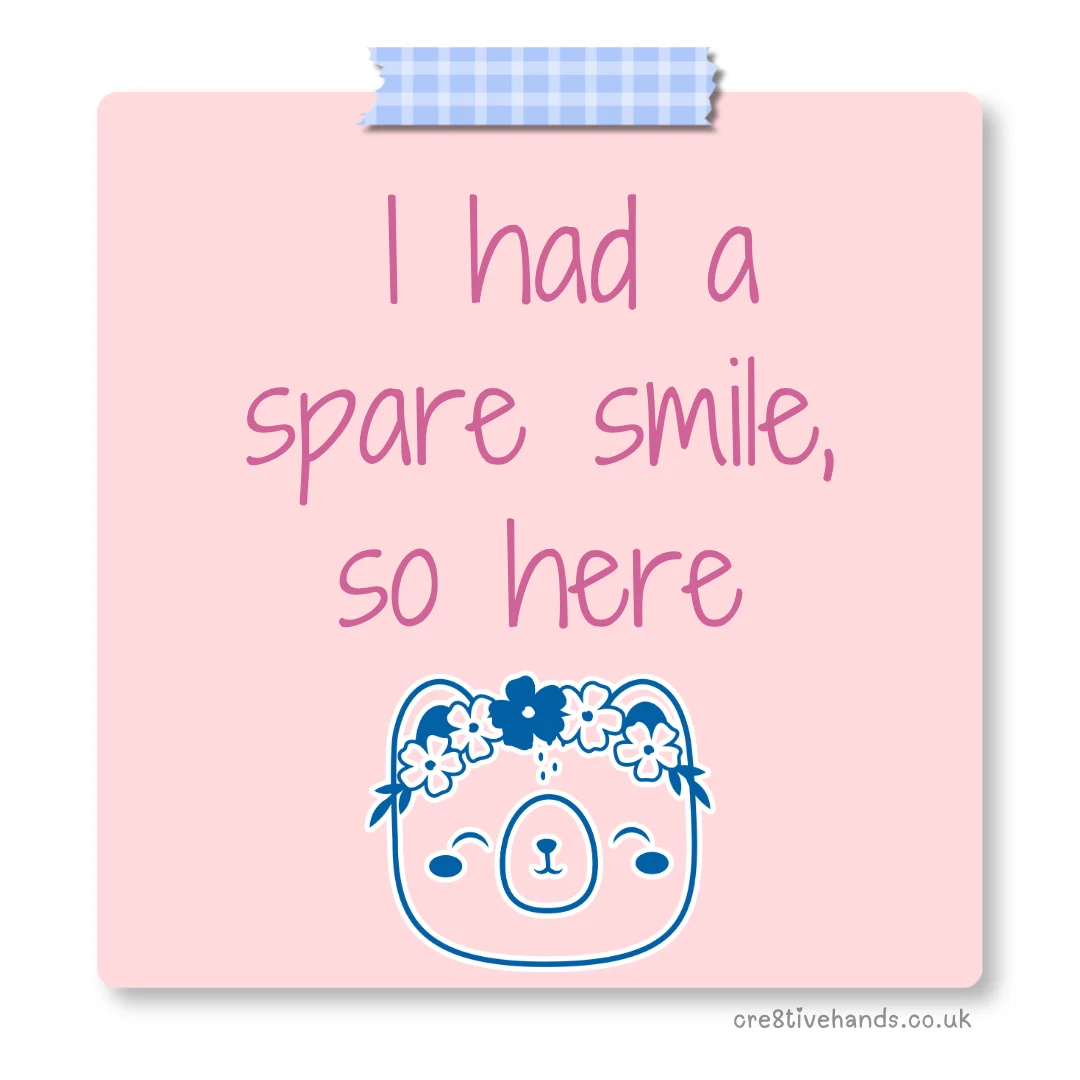 Pastel pink sticky note with the message “I had a spare smile, so here” with blue gingham tape and a cute bear face doodle.