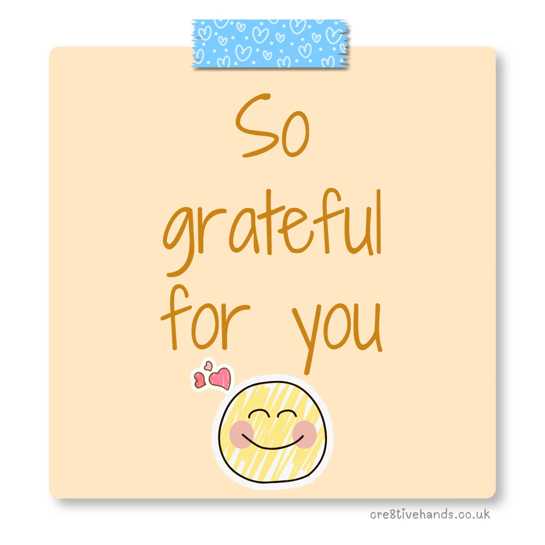 Pastel peach sticky note with the message “So grateful for you” with blue heart tape and a smiling face doodle.